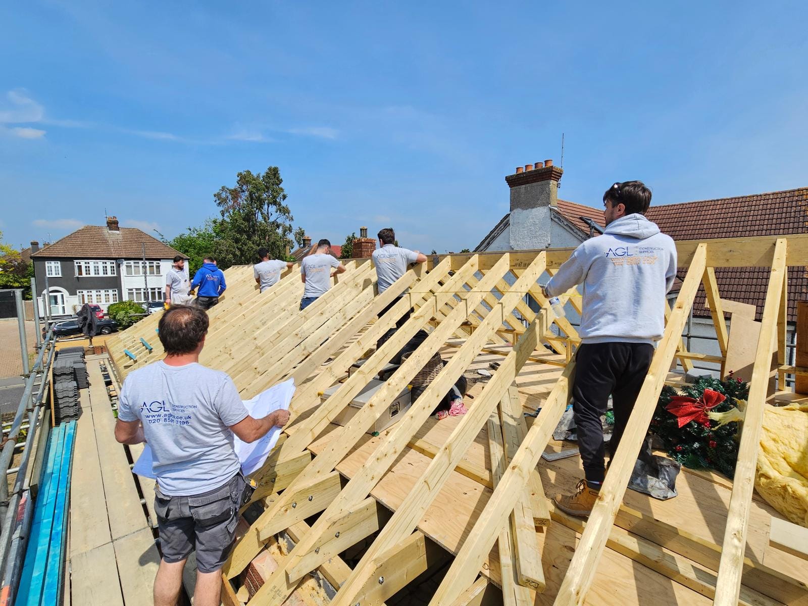 AGL team setting out the new rafters, one reading drawings on the scaffold as another stands on the timbers.