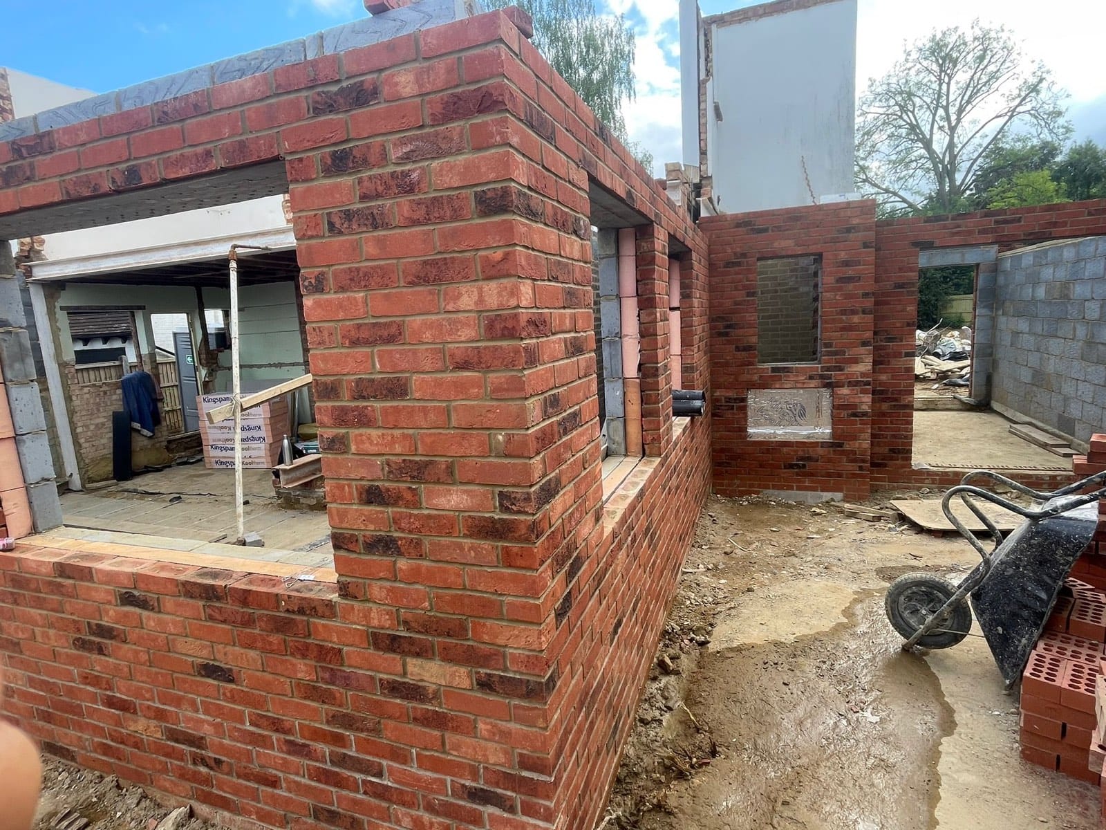 Corner of the new-build walls: facing brick outside, blockwork inner leaf, window openings formed.